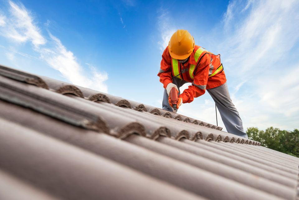 Roof Roof LLC crew installing a metal roofing system with power tools on a commercial building