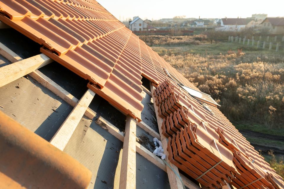 Terracotta clay tile roof installation in progress on a Texas home
