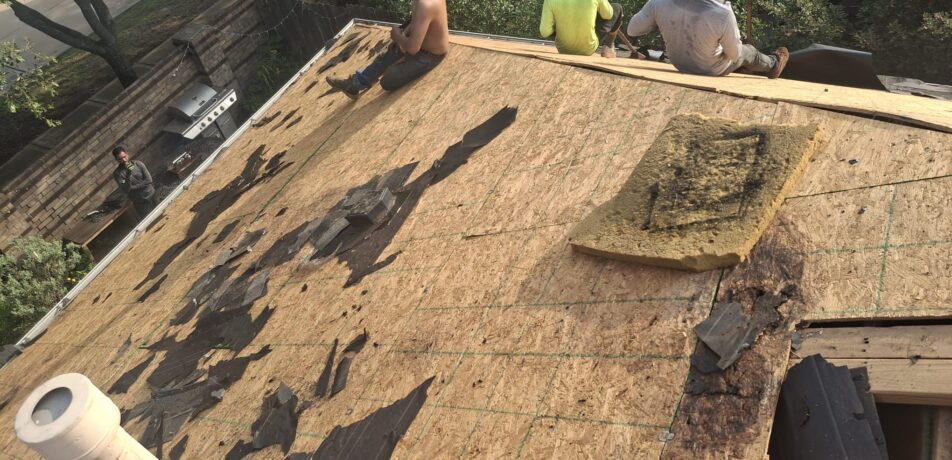 Roof Roof crew removing old roofing materials from 2-story home in Katy Texas